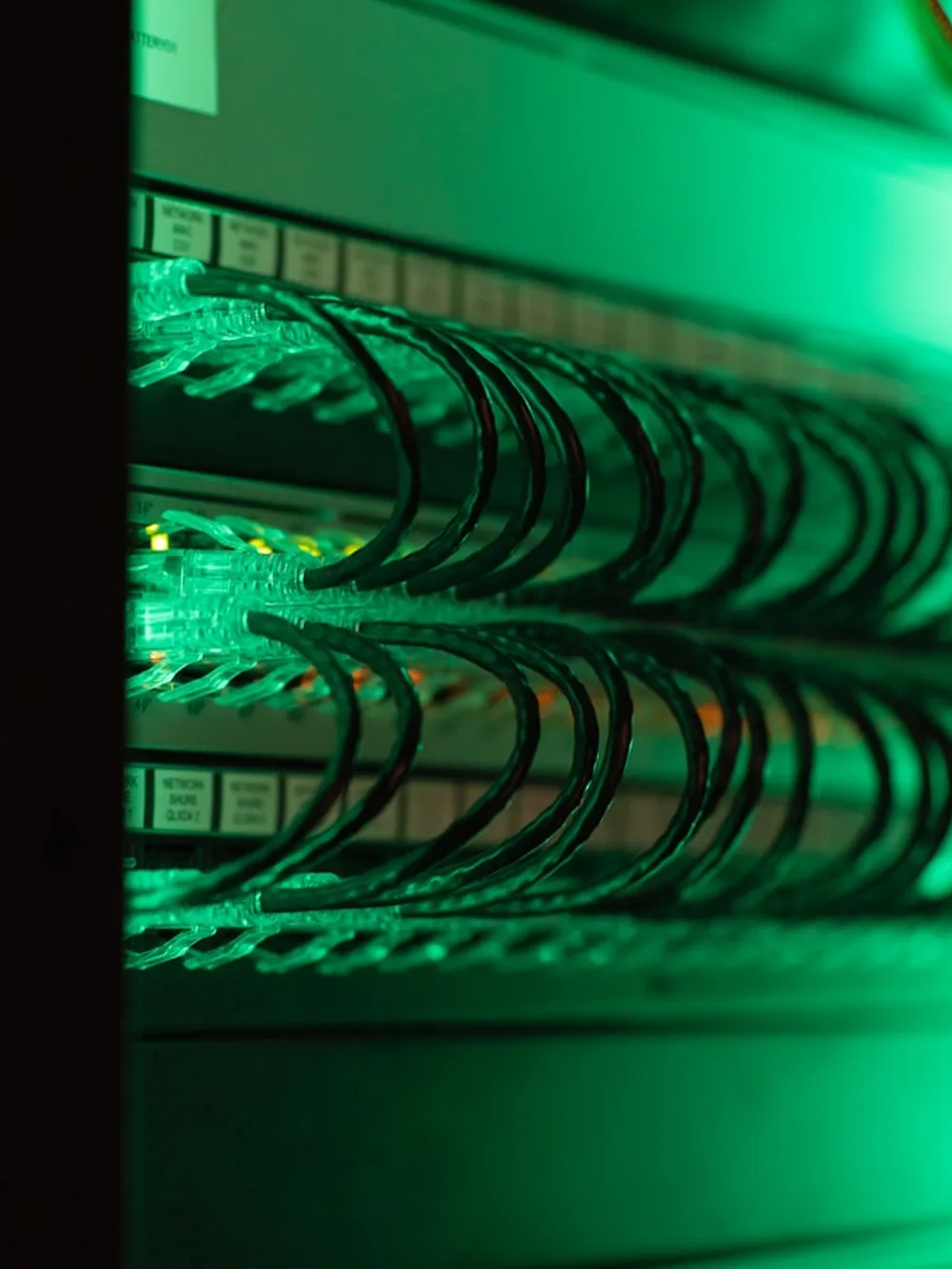 A dark server room, racks lit green from within